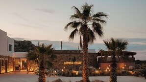 A resort named Laguna Coast with a modern building, palm trees, and a landscaped area with rocks and plants. - Laguna Coast Resort, Small Luxury Hotels of the World (Naxos)