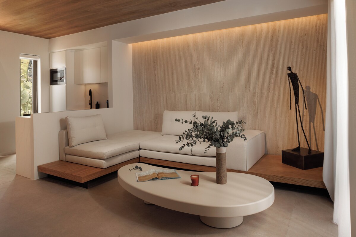 A modern living room with a sectional sofa, a coffee table, and a decorative plant.
