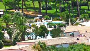 A pool area with lounge chairs and umbrellas, surrounded by palm trees and a well-maintained lawn. - Residence Cormoran, Loc. Campus Villasimius (Villasimius)