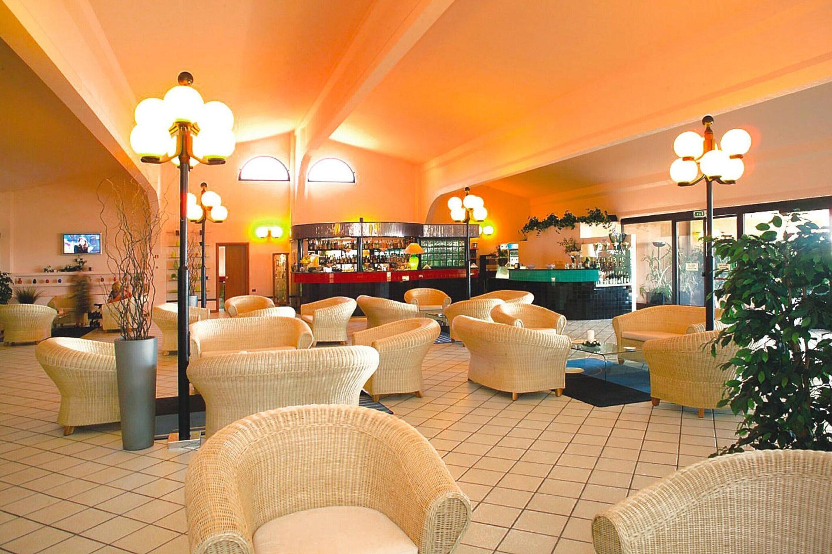 A spacious lobby with wicker furniture, a bar area, and a television screen.