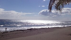 A beach with a clear sky and sunlight reflecting on the water. - Apartment, San Agustin (San Bartolomé de Tirajana)