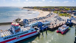 A ferry dock with a large ferry, a parking area, and a beach in the background. - Ferienwohnung, Wyk auf Fohr (Wyk auf Foehr)