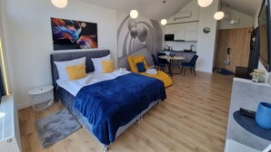 A modern hotel room with a bed, a desk, and a kitchenette. - Apartment With a View, Pool, Szklarska Poreba (Szklarska Poreba)