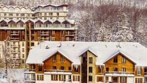 A multi-story hotel with wooden exteriors and balconies, surrounded by snow-covered trees. - Apartment With a View, Pool, Szklarska Poreba (Szklarska Poreba)