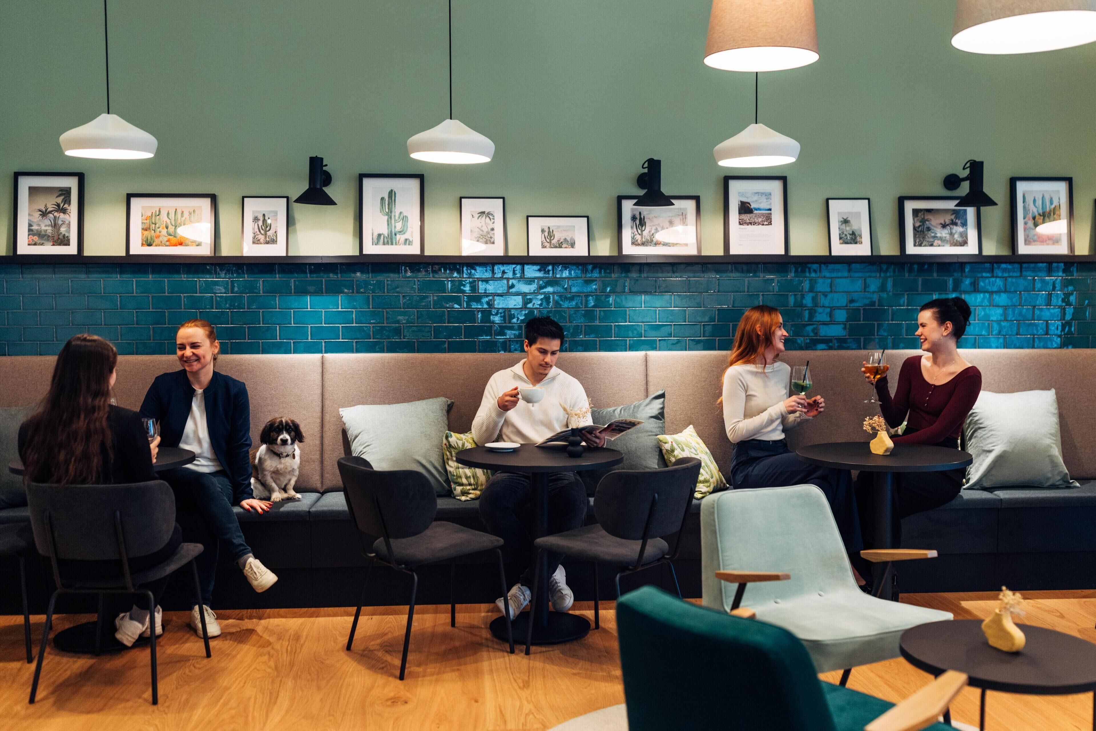 Un área de lounge moderna con disposición de asientos, un perro y obras de arte en las paredes.