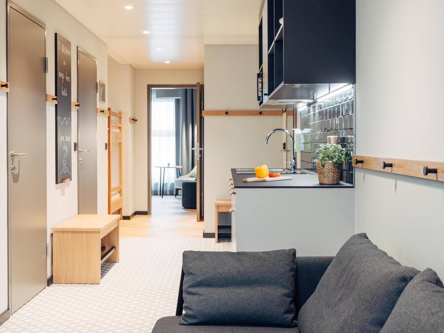 A modern kitchen with a built-in island, wooden cabinets, and a window overlooking the living area.