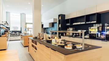 Una cocina moderna con una isla central, electrodomésticos integrados y una variedad de alimentos.