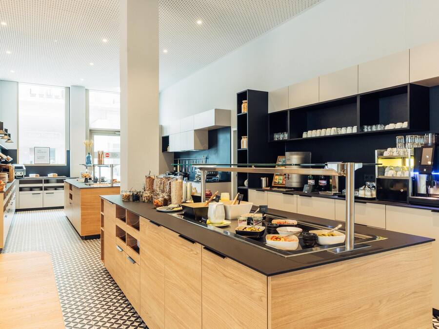 Una cocina moderna con una isla central, electrodomésticos integrados y una variedad de alimentos.
