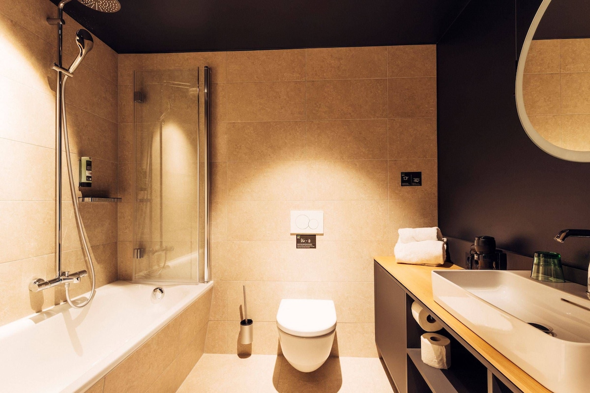 Un baño moderno con ducha, inodoro y lavamanos.