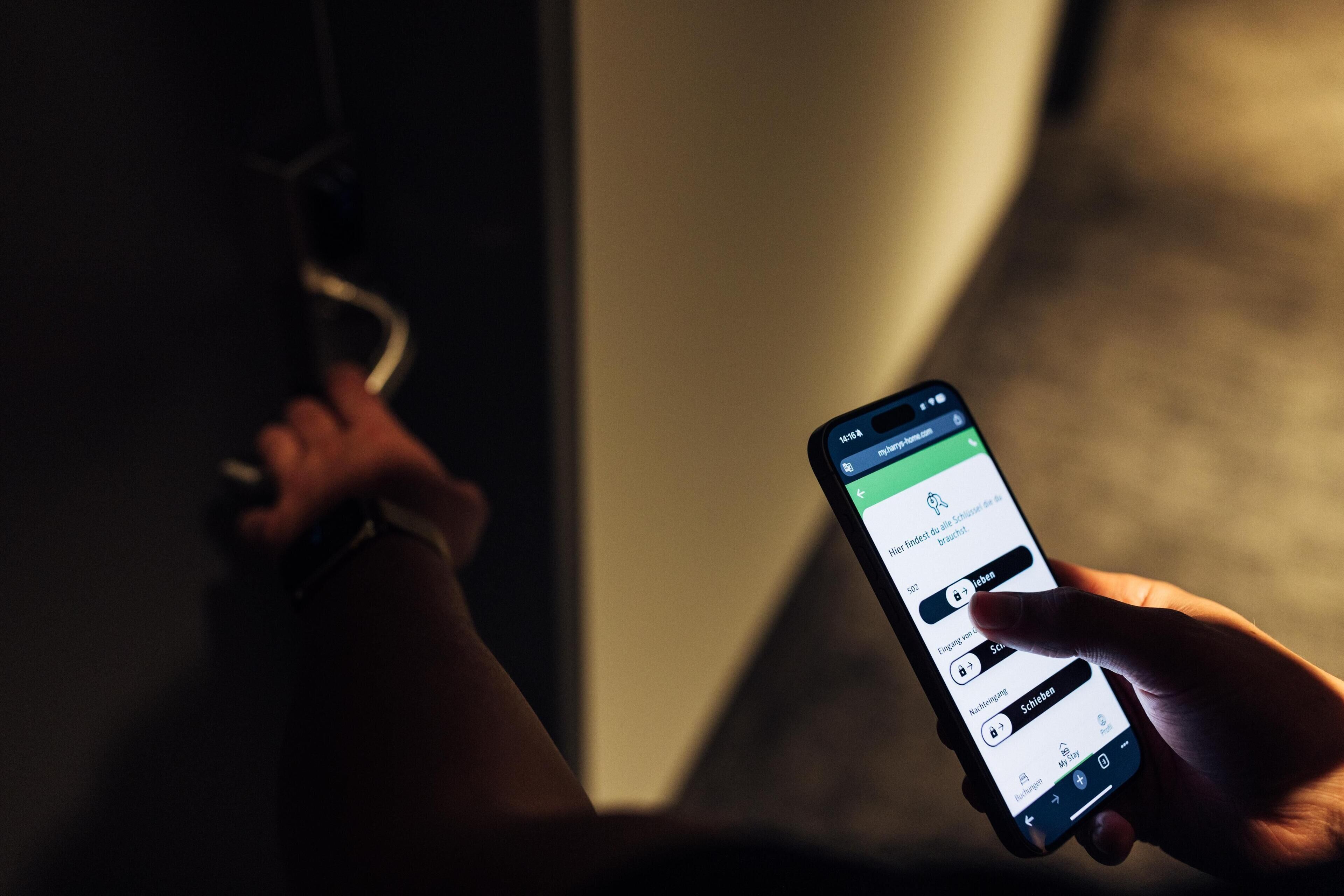 Una mano sosteniendo un teléfono inteligente que muestra una aplicación de reservas de hotel.