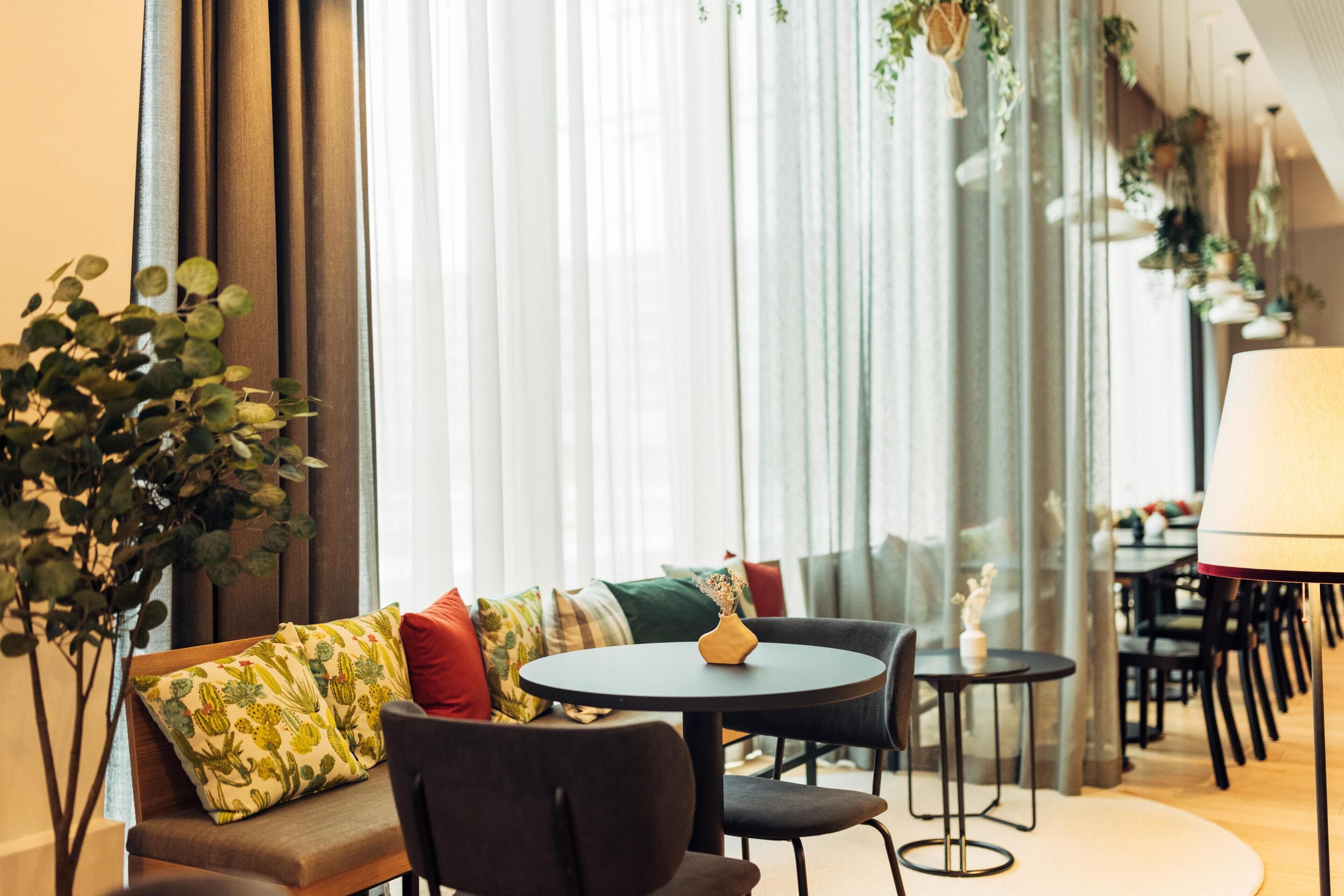 A cozy seating area with a round table, cushioned chairs, and a variety of pillows.