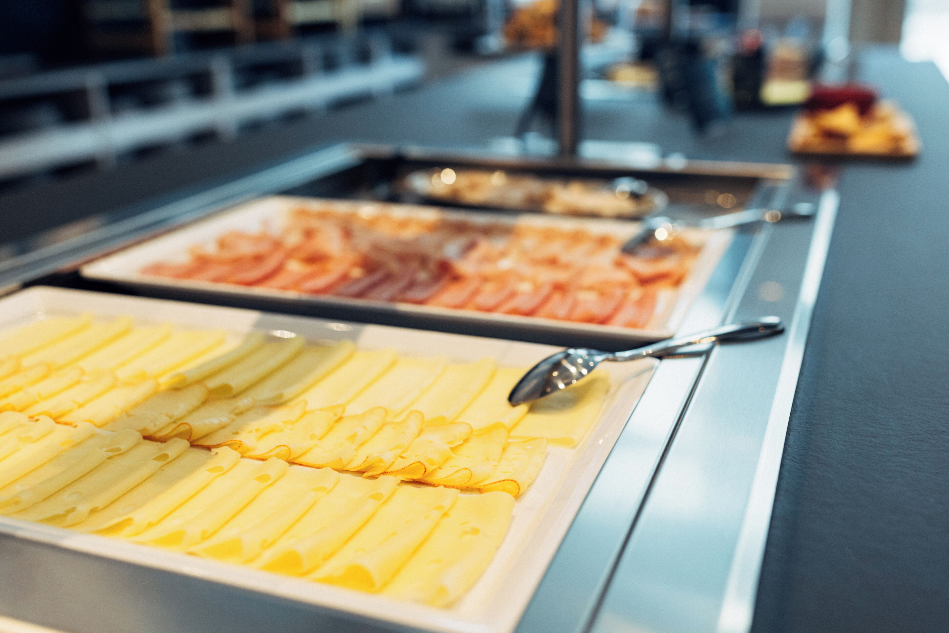 Un buffet con diverse opzioni di cibo, tra cui waffle, pancetta e altri piatti.