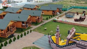 Un modellino di un complesso di casette in legno, con un’area giochi e una grande nave gonfiabile.