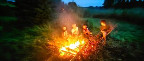 Un feu de camp autour duquel sont rassemblées des personnes.