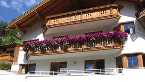 Ein mehrstöckiges Gebäude mit hölzernen Balkonen und Blumenkästen.