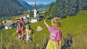 Ein ländliches Dorf mit Kirche, Häusern und blauem Himmel.