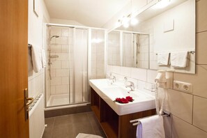 A modern bathroom with a shower, a double sink, and a vanity. - Apartment in Ischgl for Winter Sports Enthusiasts (Ischgl)