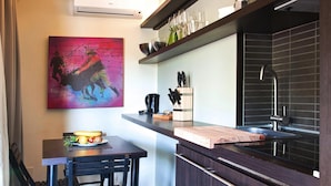 A compact kitchen with a dark countertop, a sink, and a knife block.