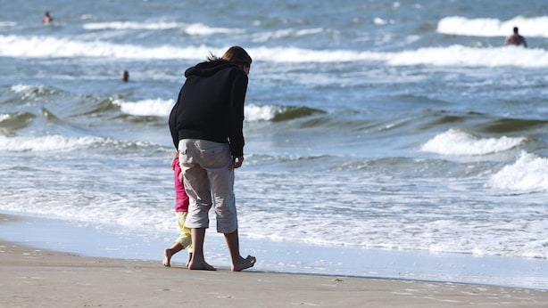 A beach scene with waves and people in the water. - Apartment in Swinoujscie Near Baltic Beach (Swinoujscie)