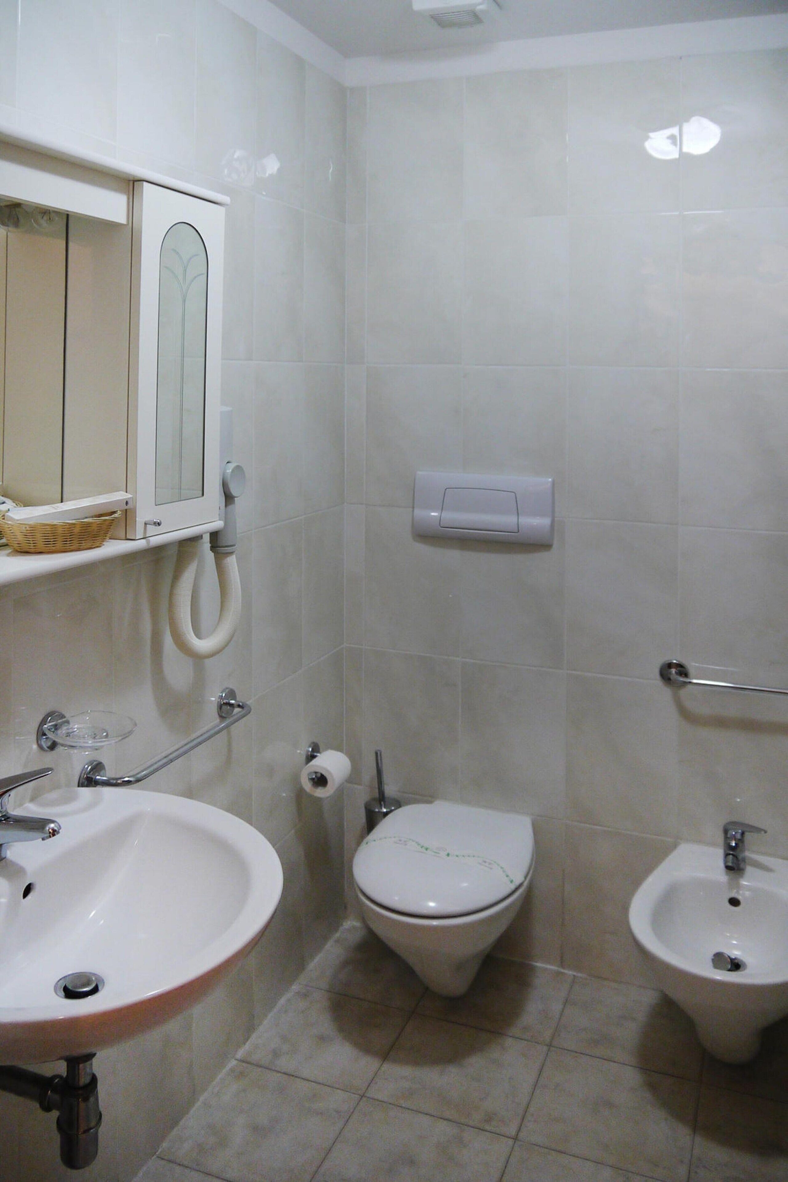 Baño con lavamanos, inodoro y bidé.