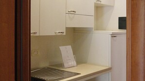 A kitchen with white cabinets, a countertop, and a sink. - Apartment in Sardinia Near Surfing Paradise (Palau)