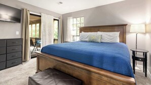 A bedroom with a large bed, a wooden headboard, a desk, and a chair. - Serenitee Pointe; Resort Access Indoor/Outdoor Pools & Hot Tub! (Branson)