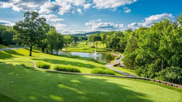 A golf course with a pond, trees, and a clear sky. - Serenitee Pointe; Resort Access Indoor/Outdoor Pools & Hot Tub! (Branson)
