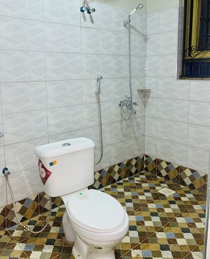 A bathroom with a toilet, shower, and tiled floor. - Luxury One Bedroom Apartment Kampala Uganda. (Kampala)