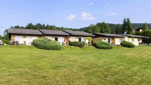 A row of yellow buildings with satellite dishes, surrounded by well-maintained lawns and trees. - Bungalow on Lake Klopein With Garden (Sankt Kanzian am Klopeiner See)