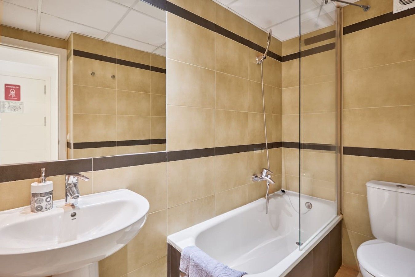 Un baño con bañera, lavabo e inodoro.