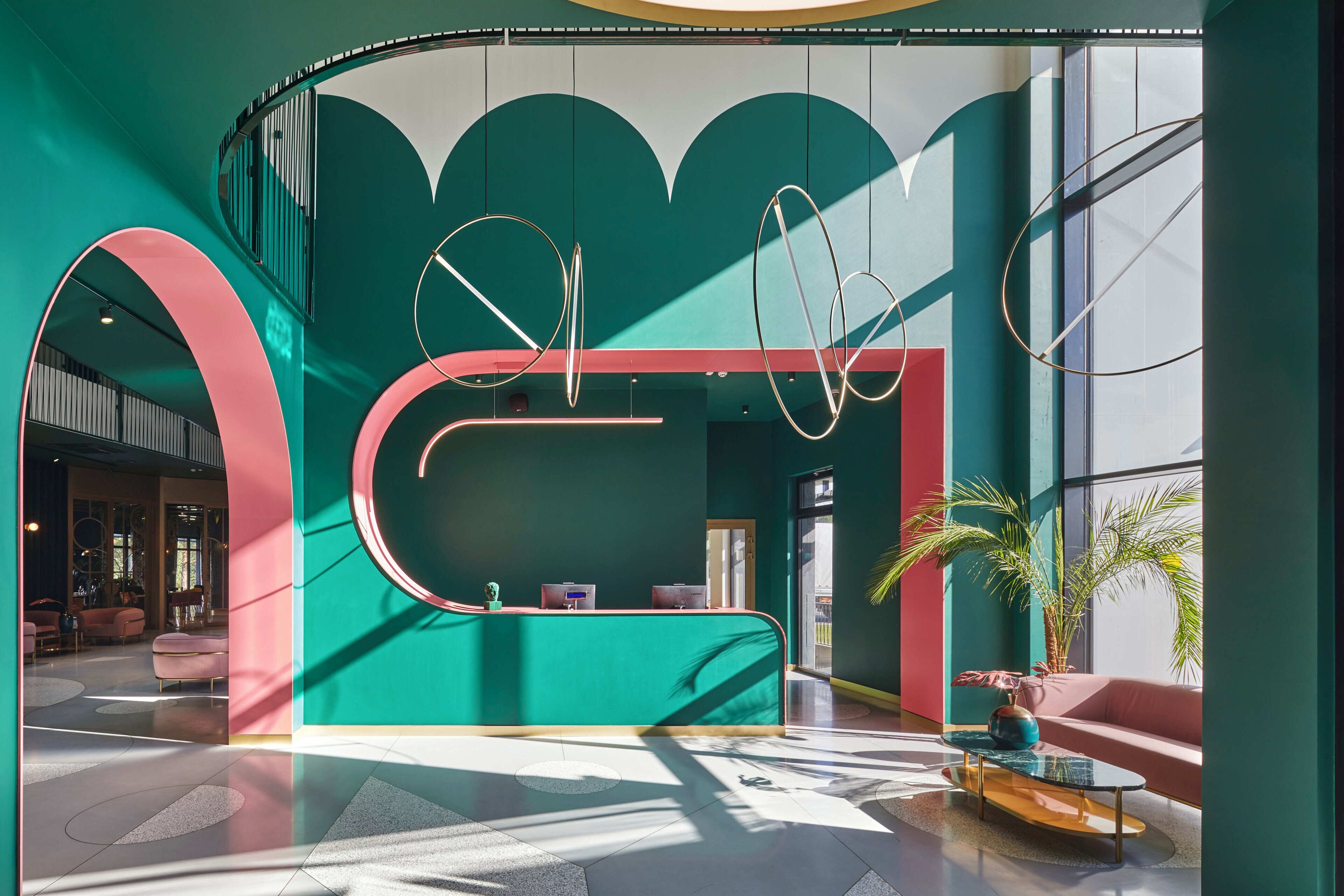 Un área de recepción moderna con un mostrador curvo, ventanas amplias y una escalera.