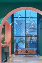 Un moderno vestíbulo con un amplio ventanal de arco, un sofá, una mesa de centro y una planta en maceta.