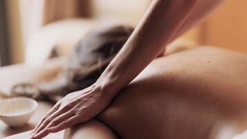 A close-up of a hand applying pressure to a person's back.