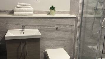 Une salle de bain moderne avec un lavabo, des toilettes et une douche à parois de verre.