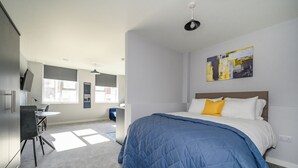 A modern bedroom with a large bed, a desk, and a chair. - Marygate by Deuce Hotels Ltd (Wakefield)
