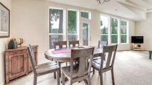 A dining area with a round table, wooden chairs, a cabinet, and a television. - Lakefront Snohomish Home ~ 13 Mi to Historic Dtwn (Snohomish)