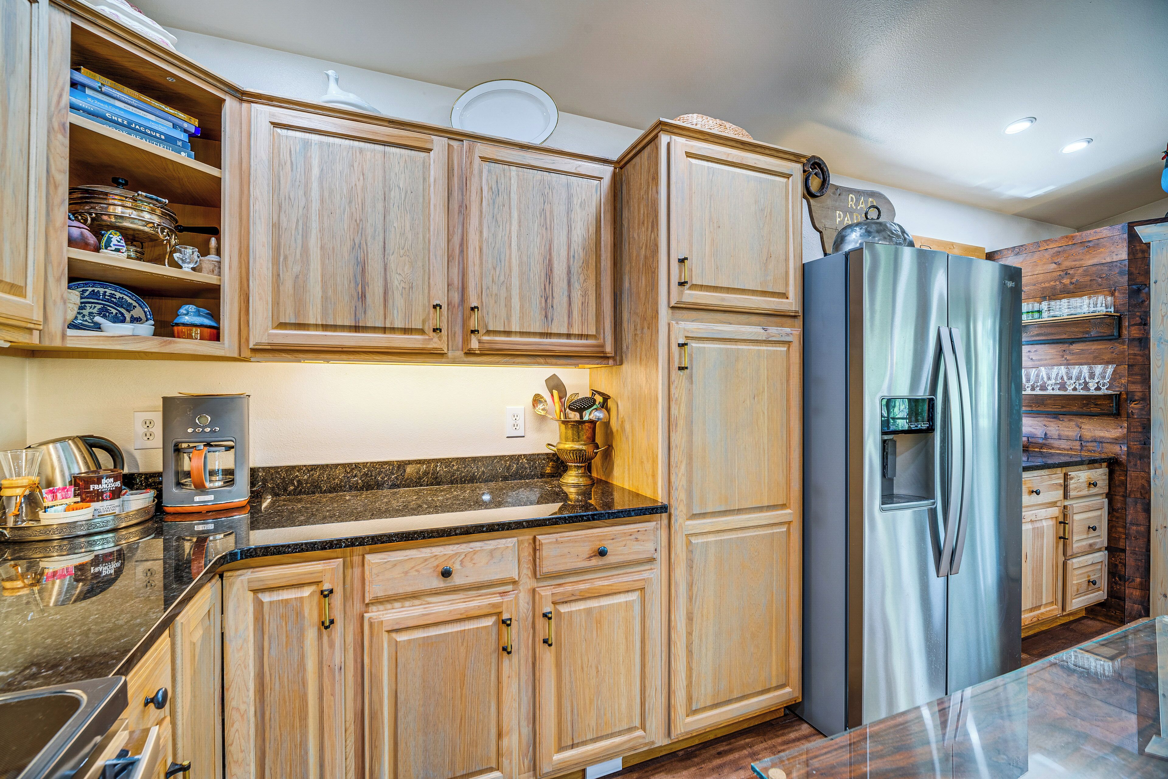A kitchen with wooden cabinets, a stainless steel refrigerator, and a coffee maker.