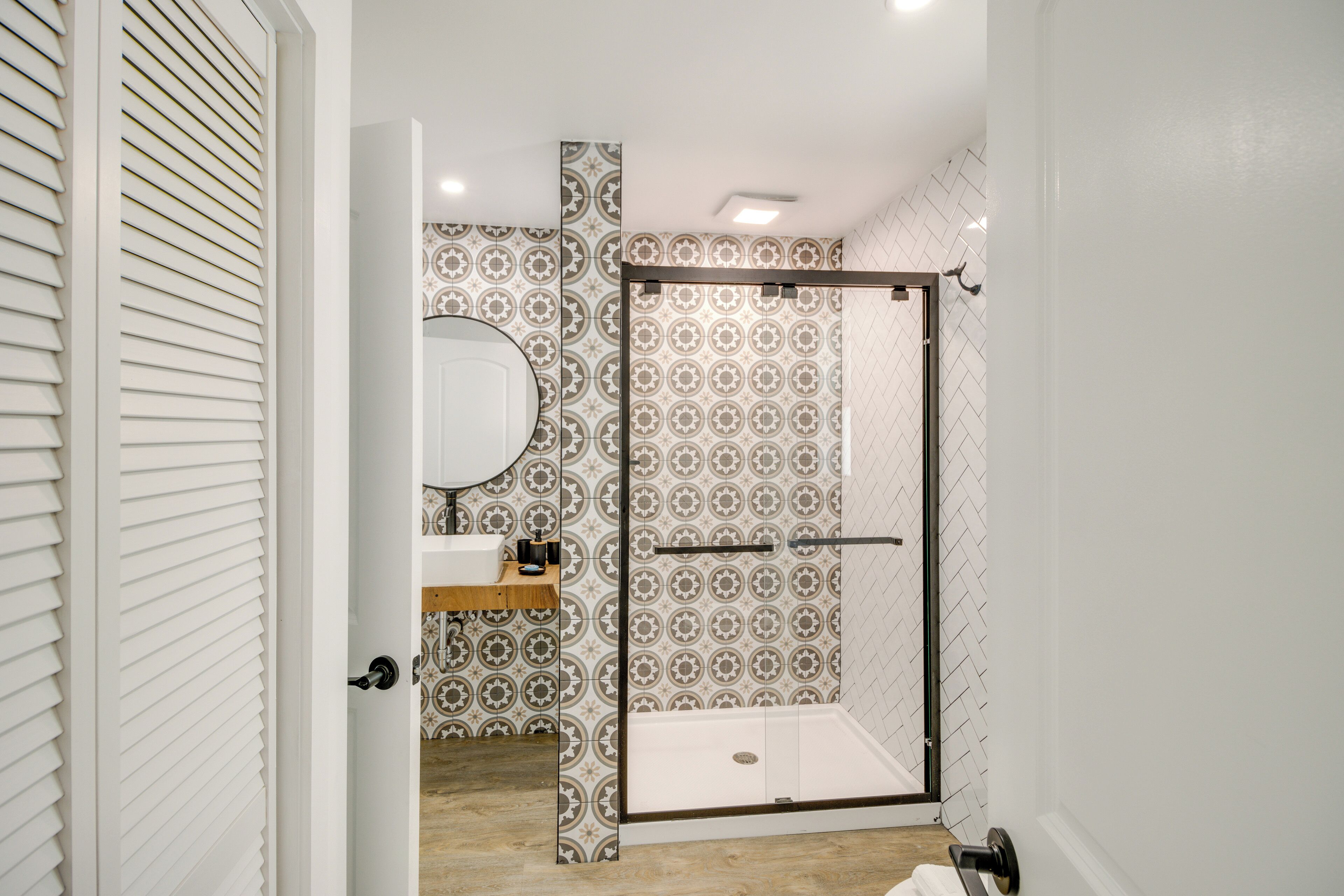 A bathroom with a shower, a sink, and a mirror.