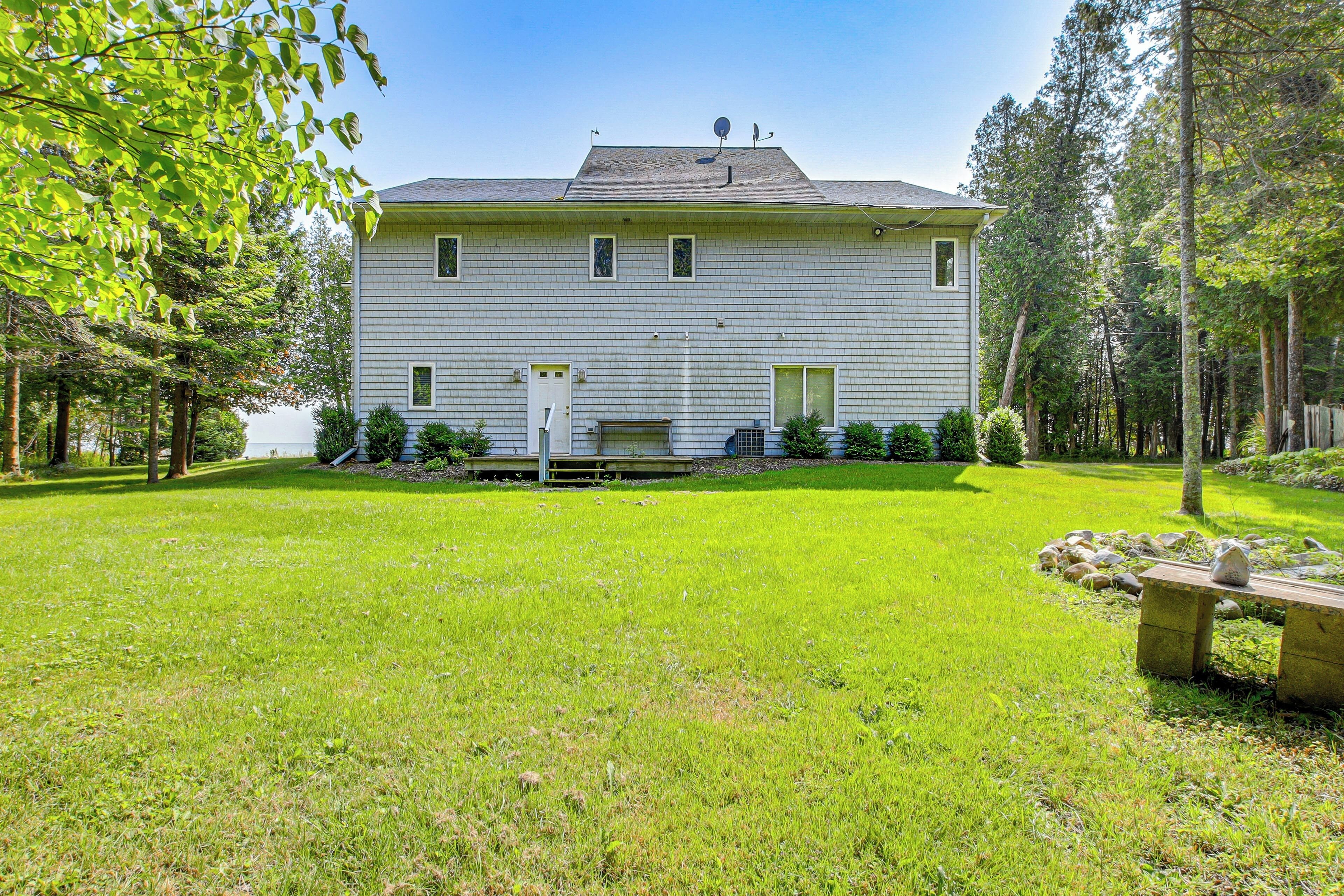 A two-story house with a front yard, a bench, and a small garden area.