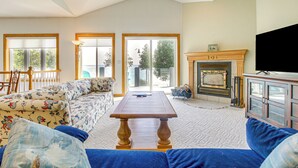 A living room with a sofa, a coffee table, and a fireplace.
