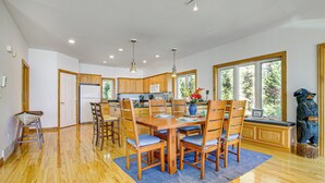 A spacious kitchen with wooden cabinets, a central island, and pendant lighting.