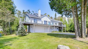 A two-story house with a garage, a covered porch, and a well-maintained lawn.