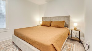 Un dormitorio con una cama grande, una mesita de noche y una lámpara.