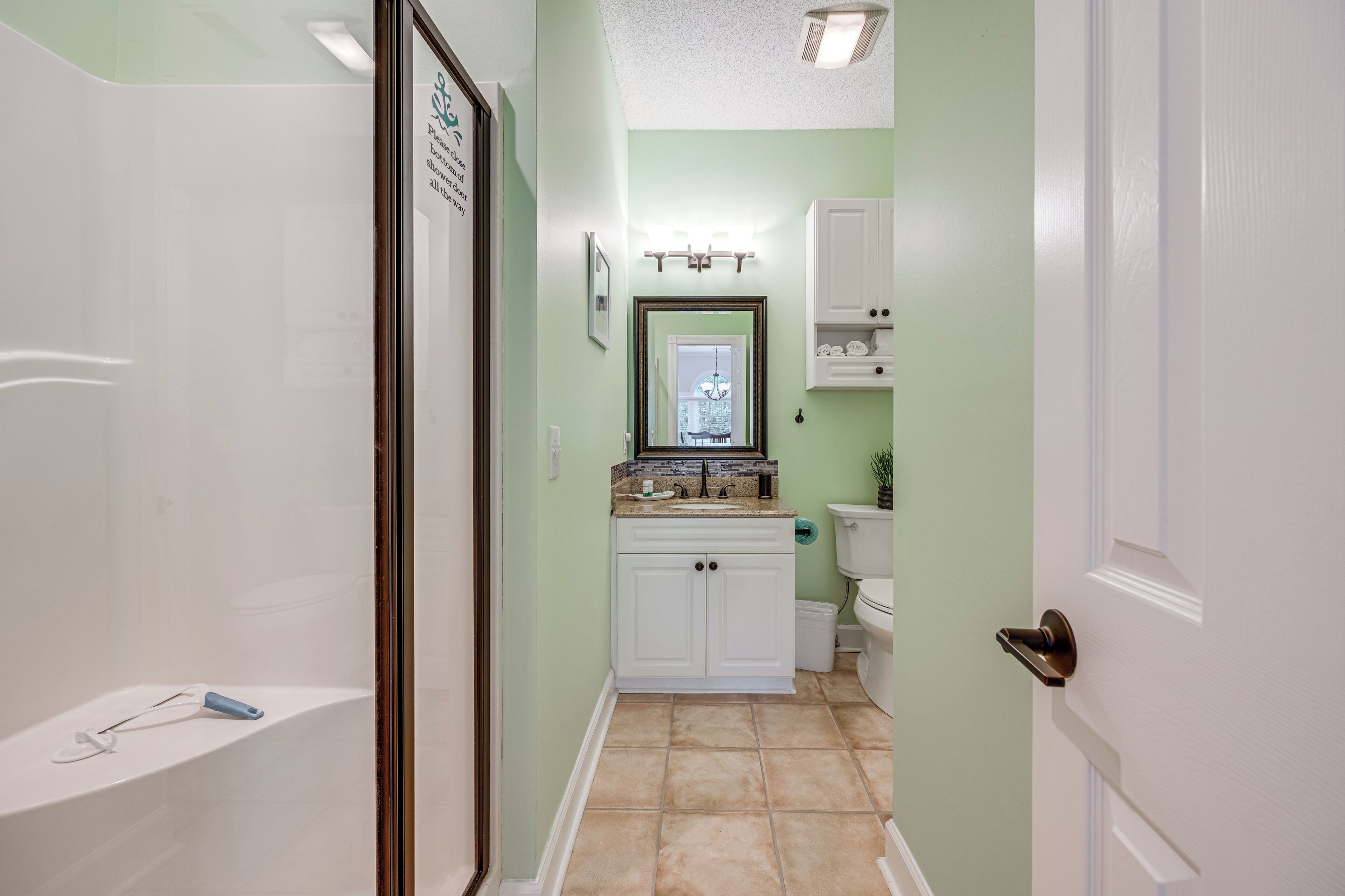 A bathroom with a shower, toilet, and sink.