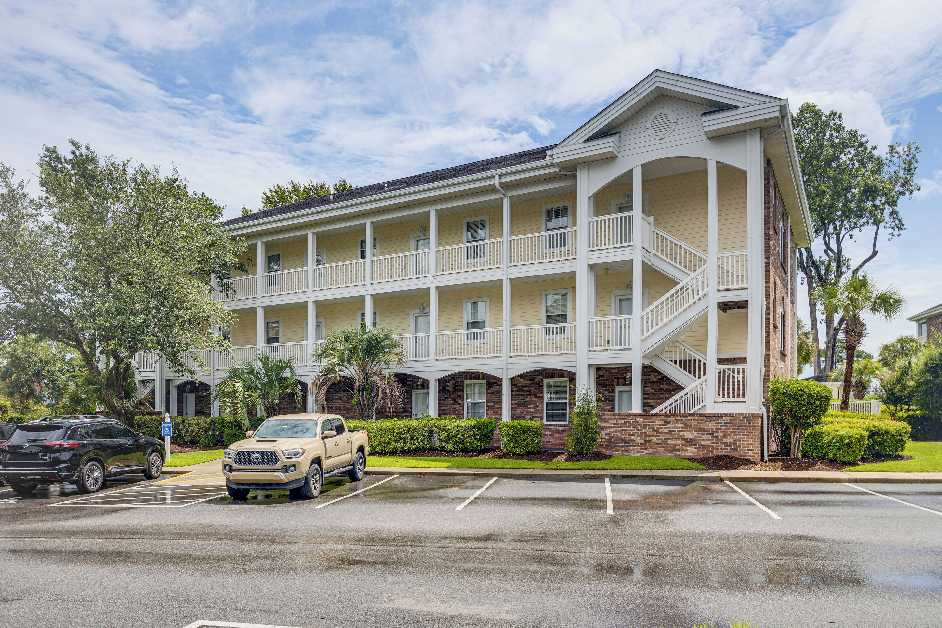 A multi-story building with a central courtyard, featuring balconies and a brick facade.