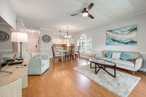 A spacious living room with a dining area, a ceiling fan, and a large window with blinds. - Pool Access! Myrtle Beach Condo, 7 Mi to Boardwalk (Myrtle Beach)