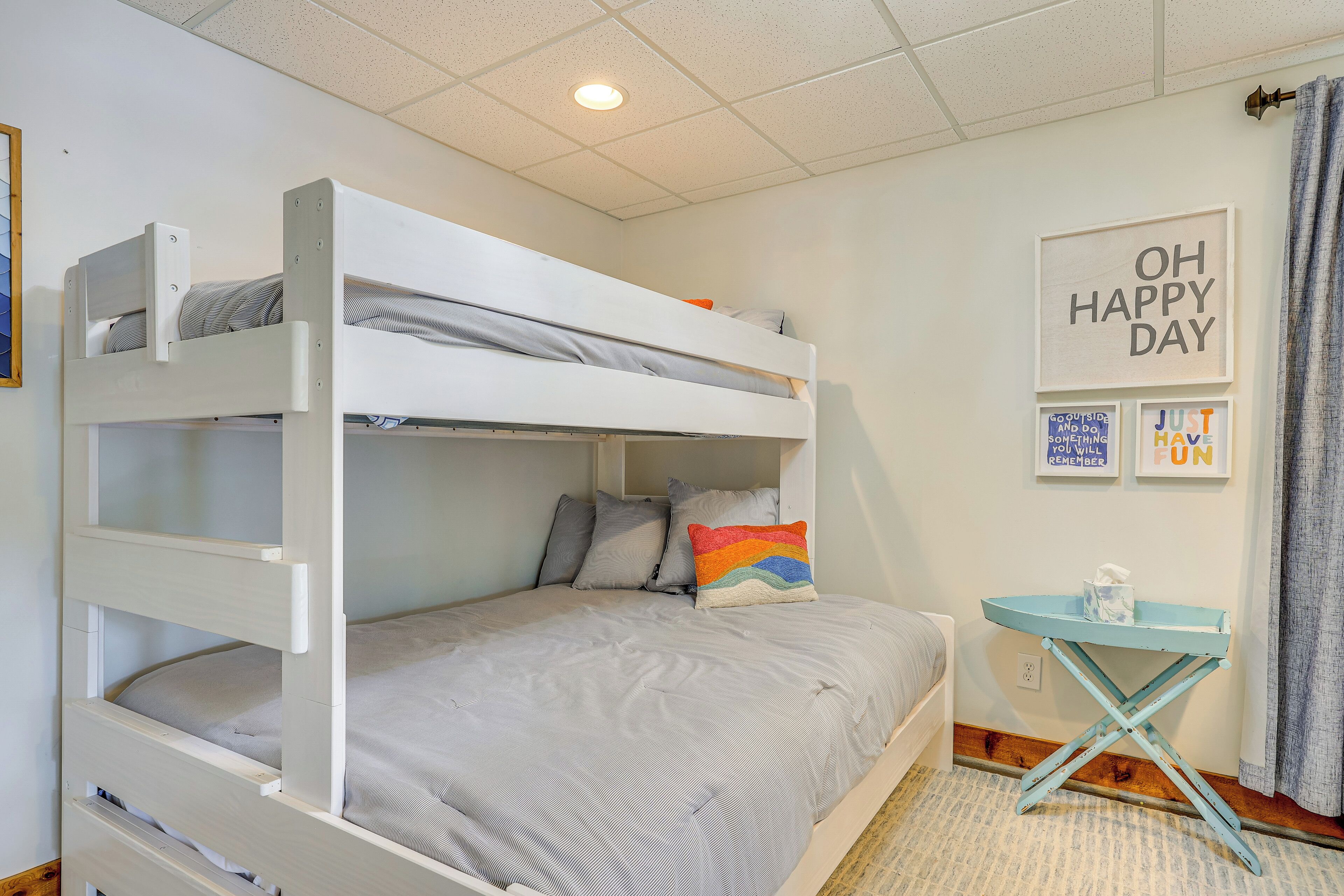 A bunk bed with a small table and a wall with motivational posters.