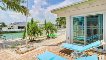 Relax in a serene outdoor space with a patio, palm trees, and a garden, perfect for unwinding.
