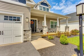 A two-story house with a garage, a covered porch, and a stone foundation. - Home ~ 3 Mi to Penn State: Pets Welcome! (State College)