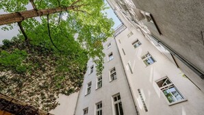 Un edificio de varios pisos con un árbol en primer plano.